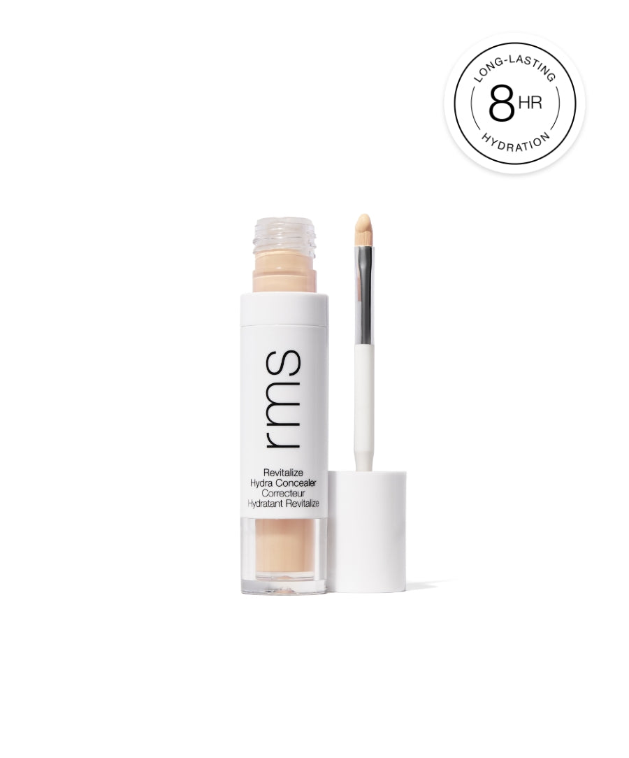 Open tube of Revitalize Hydra Concealer with applicator brush showing light beige creamy makeup, highlighting long-lasting hydration for 8 hours.