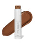 White bottle of ReEvolve Natural Finish Liquid Foundation by RMS Beauty with a brown foundation swatch behind it, showcasing clean beauty and natural ingredients.