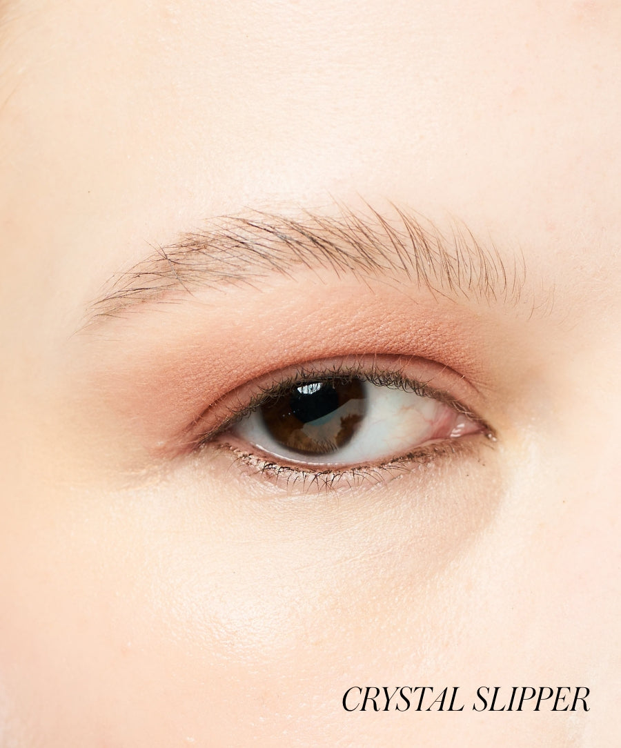 Close-up of a brown eye with soft peach-toned Eyelights Cream Eyeshadow applied to the eyelid, showcasing a natural and subtle makeup look.