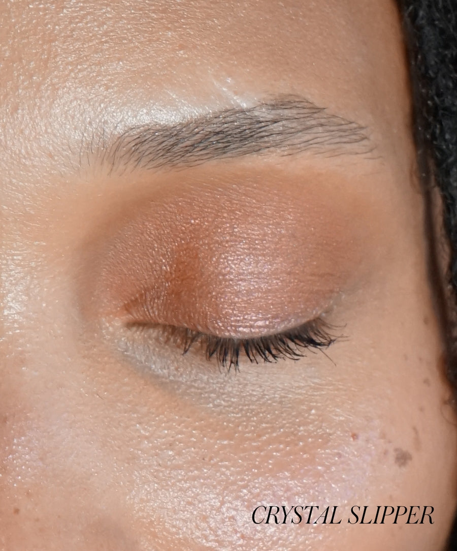 Close-up of a closed eye with shimmery neutral-toned Eyelights Cream Eyeshadow applied on the eyelid, showcasing smooth, radiant coverage and natural ingredients in clean beauty makeup.