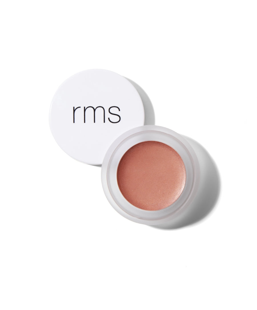 Open jar of Lip2Cheek cream blush in a warm peachy tone with a white lid featuring the rms logo, showcasing sustainable packaging and clean beauty ingredients.
