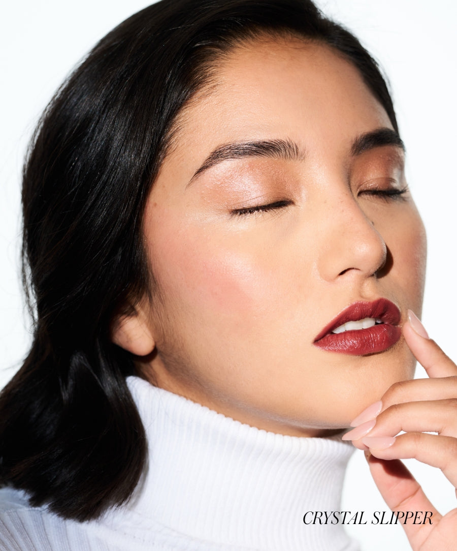 Close-up of a woman with glowing skin and subtle shimmer on her eyelids wearing Luminizer makeup, highlighting natural beauty with clean, radiant finish.