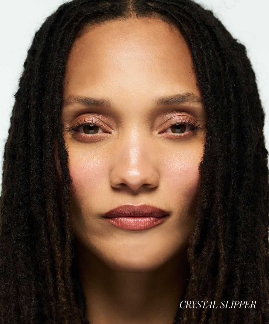 Close-up of a woman with natural makeup highlighting radiant, glowing skin using Luminizer, showcasing clean beauty and skincare infused makeup for a subtle luminous effect.