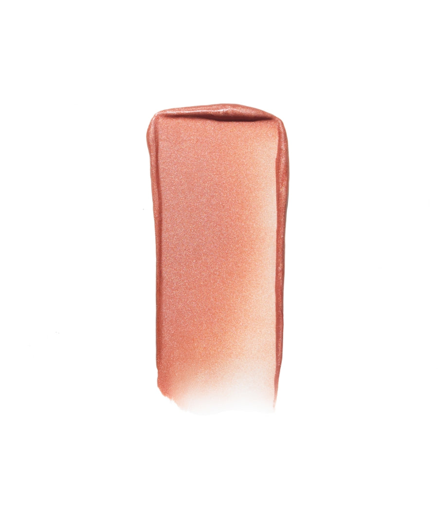 Smooth swatch of Luminizer in a warm, shimmering peachy shade showcasing its clean beauty appeal with natural ingredients and cruelty free makeup benefits.