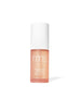 Bottle of Radiance Lock Setting Mist by RMS Beauty, featuring a sleek design with a white cap and peach-colored liquid, promoting clean beauty and natural ingredients.