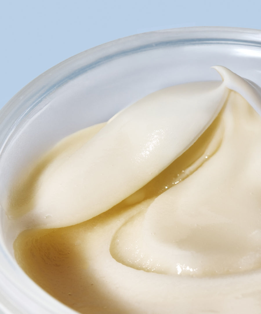 Close-up view of the smooth, creamy texture of Coconut Clean Cleansing Balm in a clear container, highlighting its natural ingredients for gentle skincare.