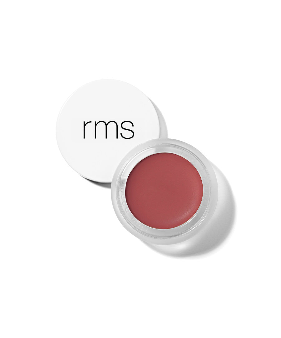 Open jar of RMS Beauty Lip2Cheek cream makeup in a muted rose shade with white lid on a white background, highlighting natural ingredients and clean beauty focus.