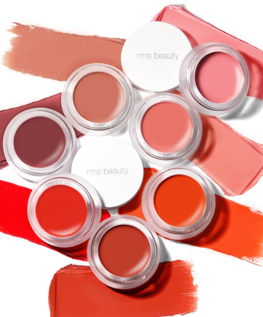 Collection of colorful cream makeup pots featuring Lip2Cheek by RMS Beauty arranged on swatches of matching natural and vibrant shades promoting clean beauty and skincare infused makeup.