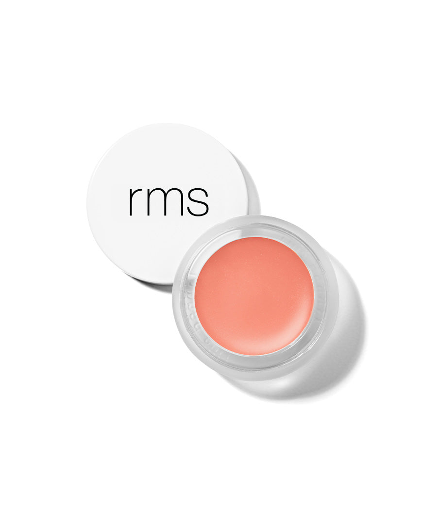 Open jar of Lip2Cheek cream blush in a soft peach shade with a white lid featuring black RMS logo, showcasing clean beauty and natural ingredients.
