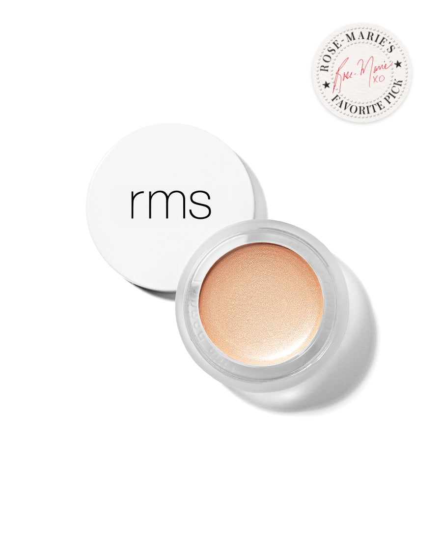 Open jar of Luminizer cream makeup with a soft champagne glow in a white container labeled rms, accompanied by a Rose-Marie’s Favorite Pick badge.