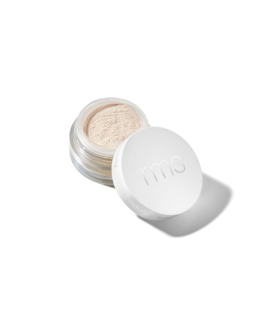 Open jar of Deluxe Mini Hydra Setting Powder - Light with a white lid embossed with rms, showing fine light powder inside, highlighting clean beauty and natural ingredients.
