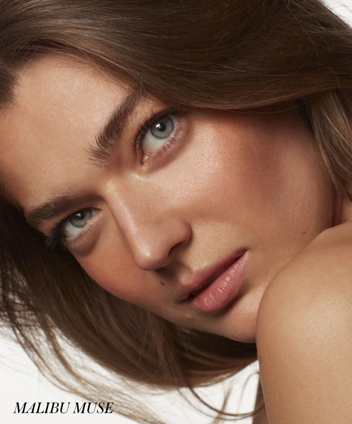 Close-up of a woman with natural, glowing skin showcasing a subtle bronzed look using ReDimension Hydra Bronzer for a radiant, clean beauty finish.