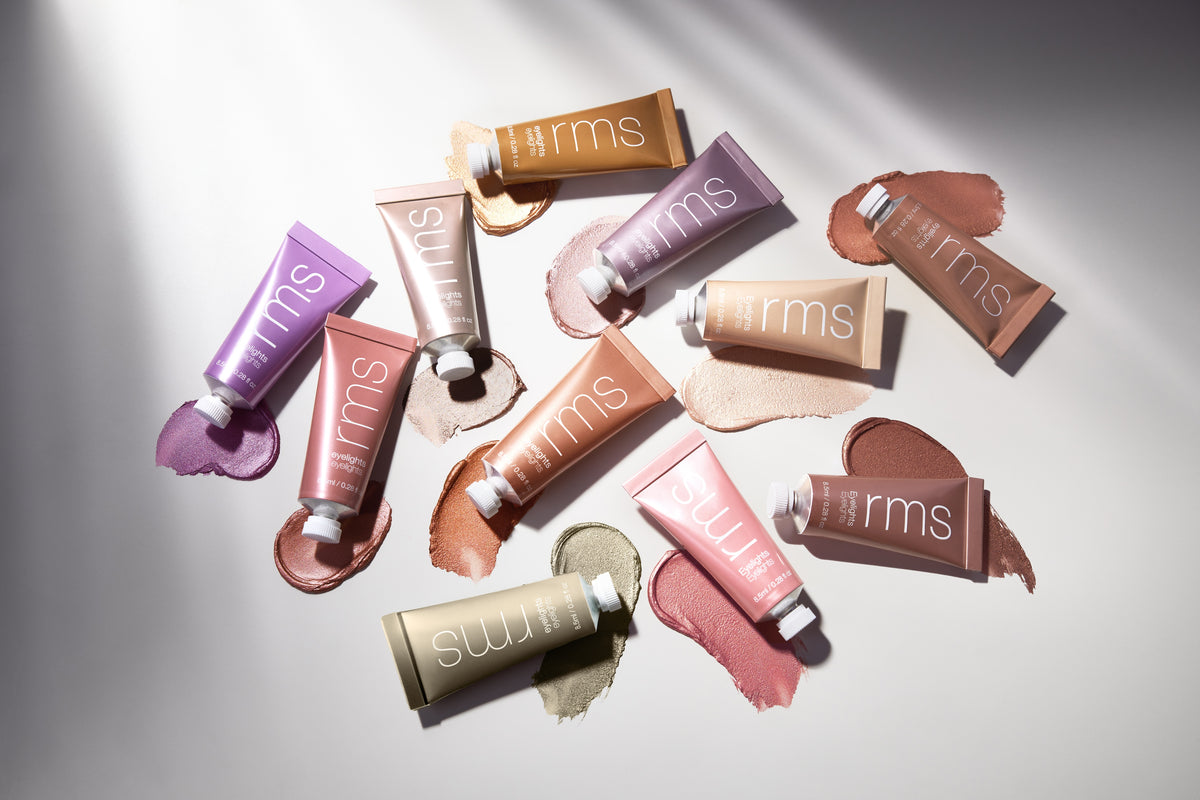 Various shades of RMS Beauty Eyelights Cream Eyeshadow tubes displayed with matching cream eyeshadow swatches on a light background, showcasing natural and clean beauty tones.