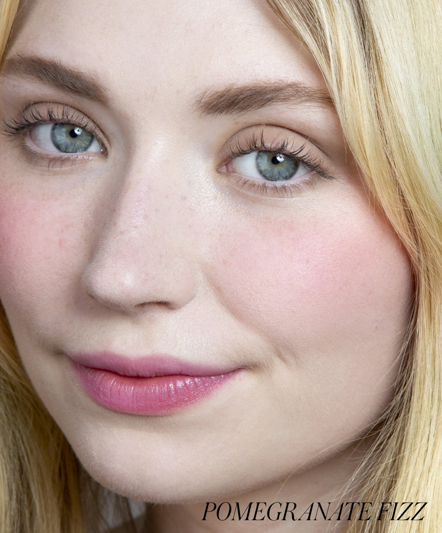 Close-up of a woman with natural makeup showcasing rosy cheeks and soft pink lips, highlighting the subtle glow of ReDimension Hydra Powder Blush for a fresh, clean beauty look.