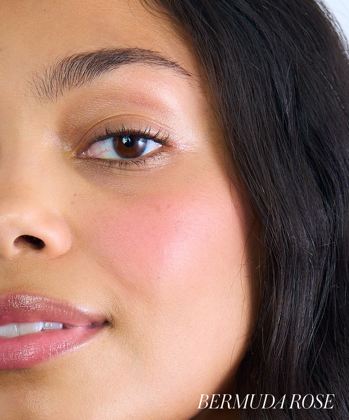 Close-up of a woman’s face showcasing soft pink cheeks enhanced with ReDimension Hydra Powder Blush, highlighting a natural, radiant look with clean beauty appeal.