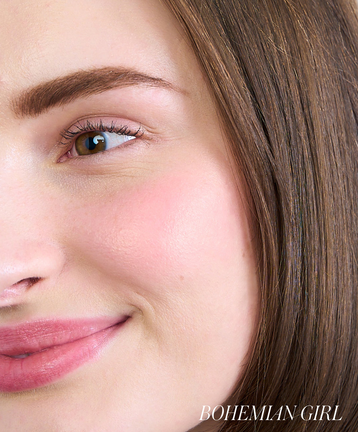 Close-up of a woman’s face with natural makeup highlighting her rosy cheeks using ReDimension Hydra Powder Blush, showcasing clean beauty and skincare-infused makeup.