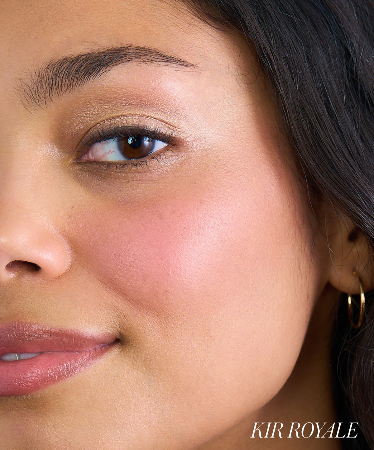 Close-up of a woman wearing rosy pink blush on her cheek, showcasing the natural, radiant finish of ReDimension Hydra Powder Blush with clean beauty and skincare-infused makeup benefits.