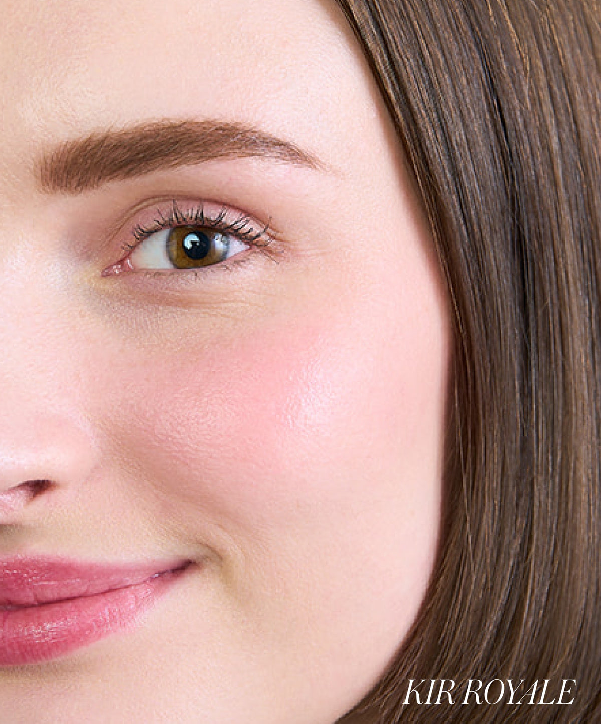 Close-up of a woman's face showcasing natural, glowing skin with soft pink cheek color from ReDimension Hydra Powder Blush, emphasizing clean beauty and skincare infused makeup.