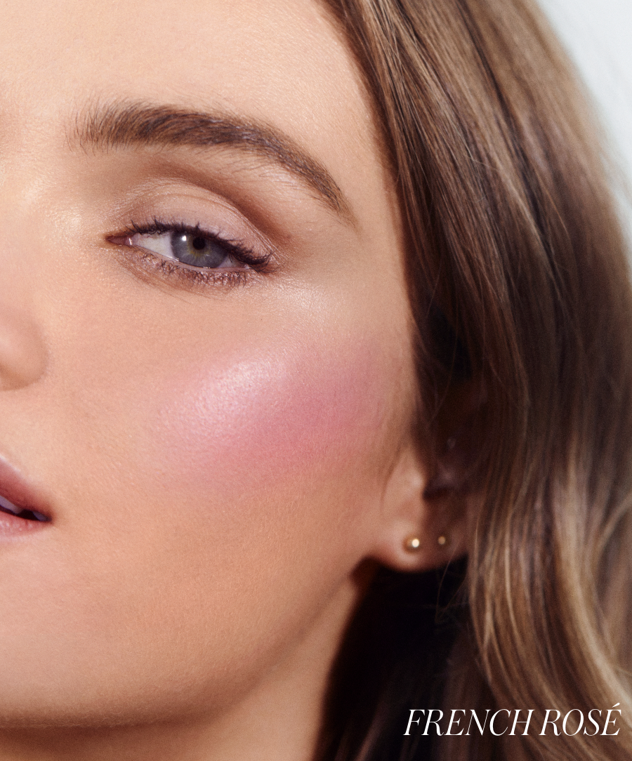 Close-up of a woman's face with natural makeup highlighting soft pink cheeks using ReDimension Hydra Powder Blush in a radiant French Rosé shade, showcasing clean beauty and natural ingredients.