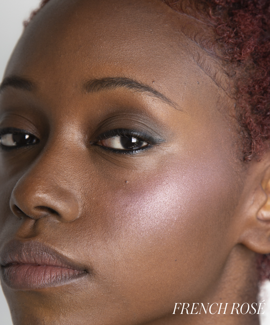 Close-up of a person with a natural makeup look featuring ReDimension Hydra Powder Blush in a subtle rosy shade on the cheek, enhancing a smooth complexion.
