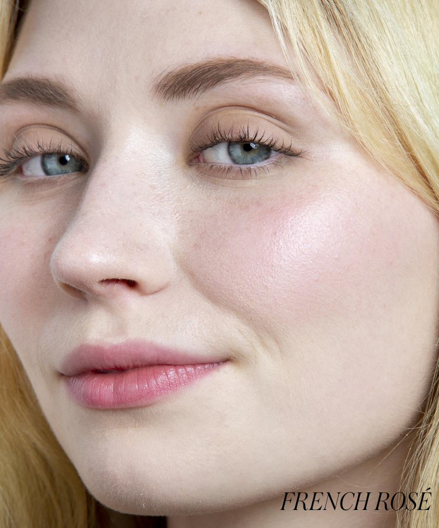 Close-up of a woman with light skin wearing ReDimension Hydra Powder Blush in a soft French rosé shade, showcasing a natural, radiant makeup look with clean beauty and skincare-infused makeup benefits.