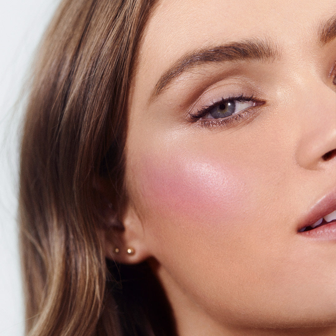 Close-up of a woman's face showcasing a natural, rosy cheek glow created with ReDimension Hydra Powder Blush, highlighting clean beauty and skincare infused makeup benefits.