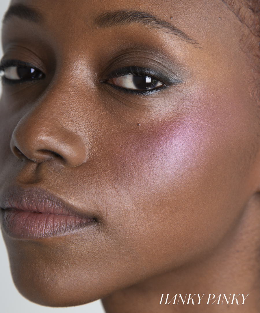 Close-up of a woman wearing ReDimension Hydra Powder Blush with a soft, radiant pink glow on her cheek, showcasing natural texture and clean beauty makeup.