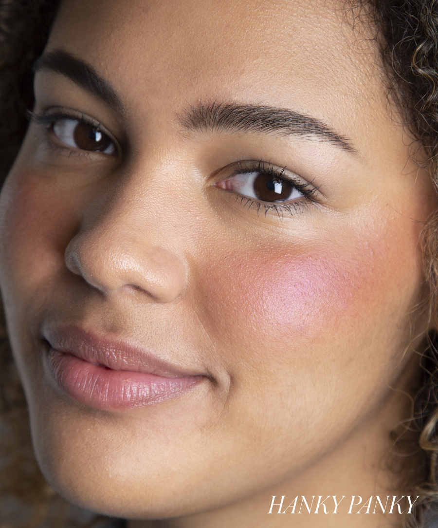 Close-up of a woman's face with natural makeup highlighting a soft pink glow on her cheeks using ReDimension Hydra Powder Blush for a radiant, clean beauty look.