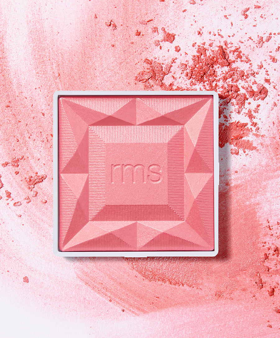 ReDimension Hydra Powder Blush in a soft pink shade with a geometric pattern embossed and scattered powder on a light pink background, featuring clean beauty and natural ingredients.