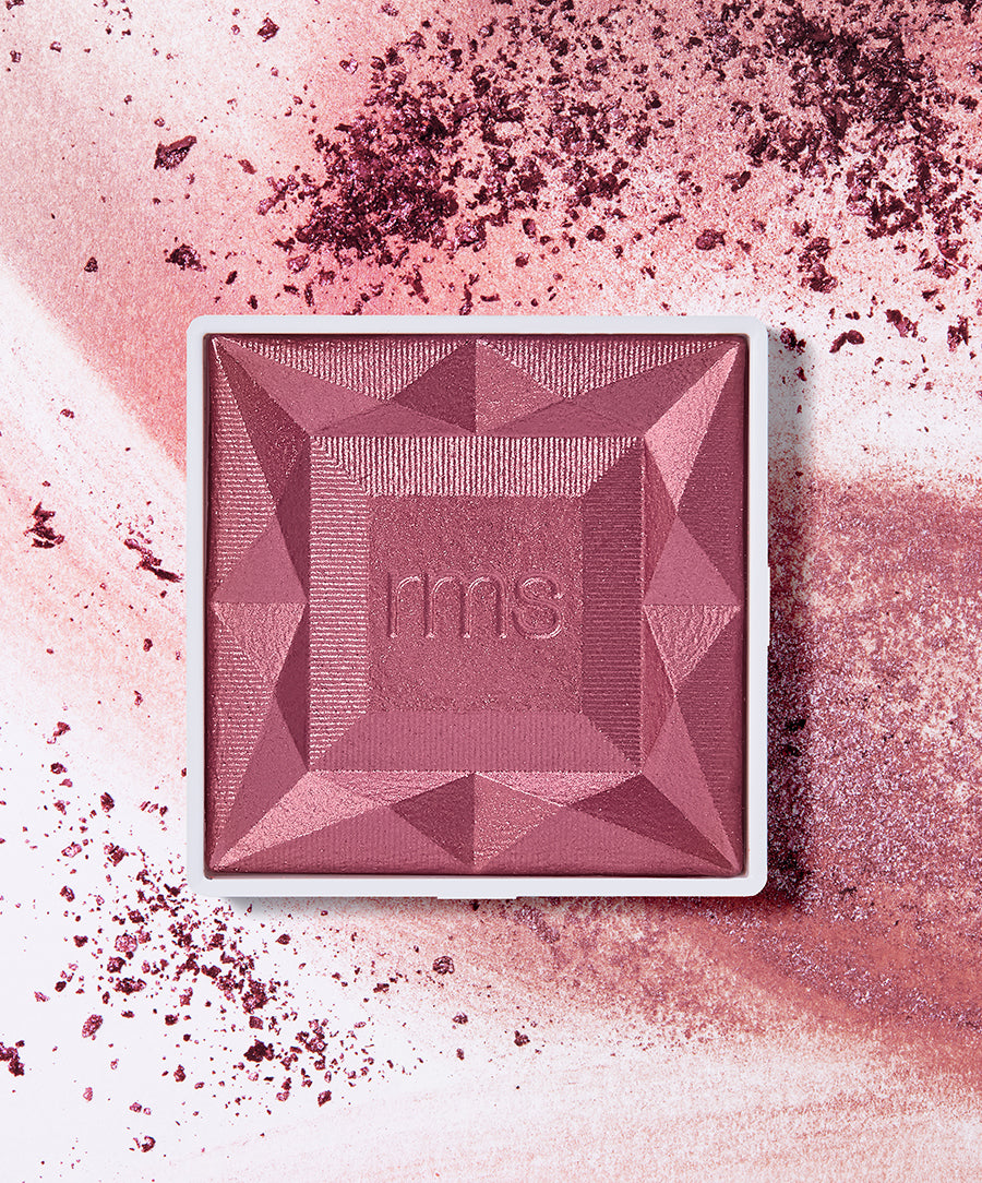 Square ReDimension Hydra Powder Blush in a deep mauve shade with geometric embossed design and scattered crushed powder on a light surface.
