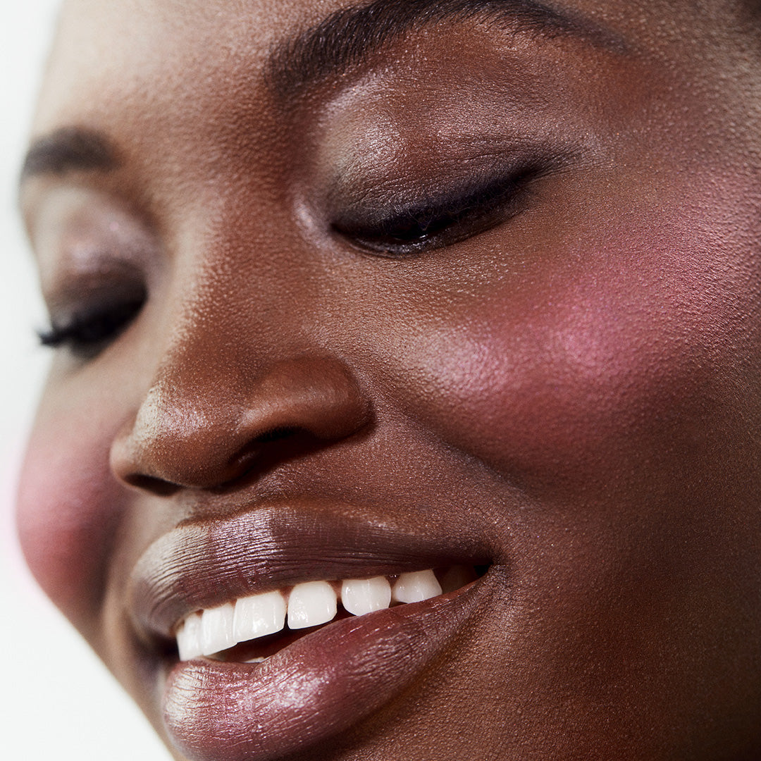 Close-up of a smiling woman with radiant skin wearing ReDimension Hydra Powder Blush, showcasing natural makeup with clean ingredients and a healthy, dewy finish.