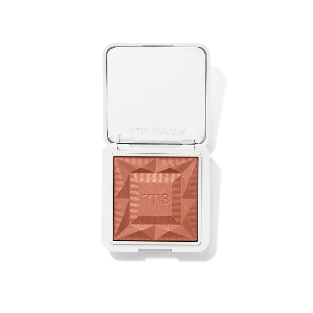 ReDimension Hydra Powder Blush in a sleek white compact, featuring a textured, warm terracotta shade embossed with the rms logo, highlighting clean beauty and natural ingredients.