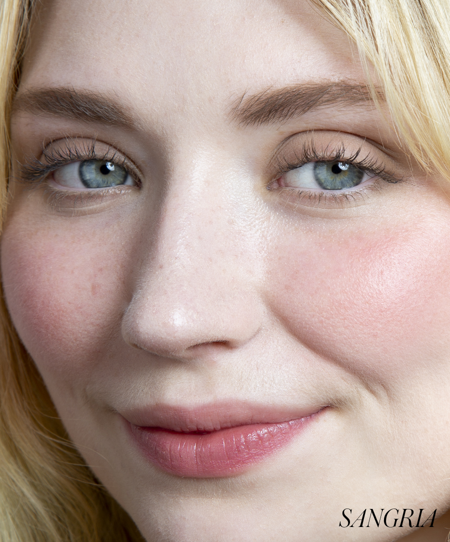 Close-up of a woman's face with natural makeup featuring soft rosy cheeks enhanced by ReDimension Hydra Powder Blush, highlighting clean beauty and natural ingredients.